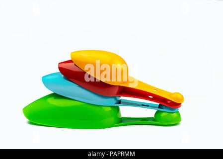 Set of colorful plastic measuring spoon isolated on white background with shadow. Green, blue, red, and orange plastic measuring spoon. Stock Photo