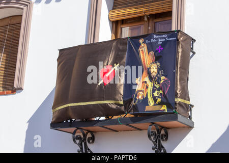 Religious Banners Hanging From a Balcony. As a Small Rural Town Celebrates Semana Santa, Easter parade, Holy Week in Spain Stock Photo