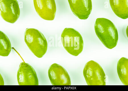 Bright top view pattern of fresh green olives on white background. Shot from above of multiple olives Stock Photo
