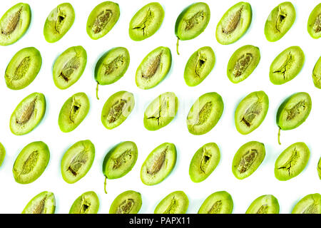 Bright top view pattern of fresh green olives cut in half on white background. Shot from above of multiple olives Stock Photo