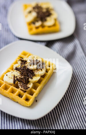 Waffle garnished with banana and chocolate shaving on plate Stock Photo