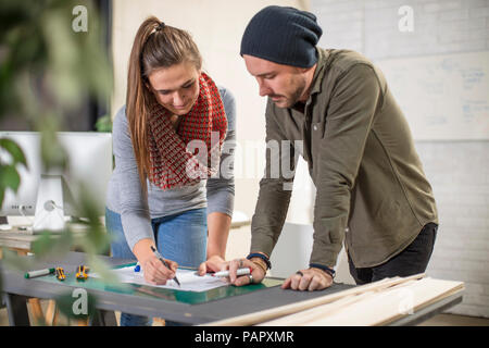Two colleagues discussing at desk in office Stock Photo