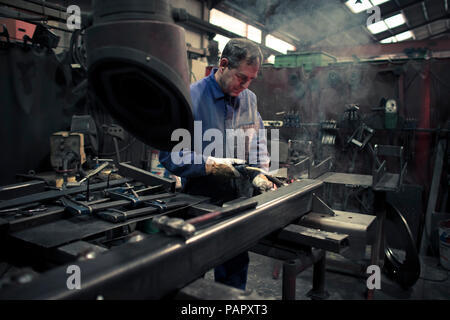 Welder welding metal in a factory Stock Photo