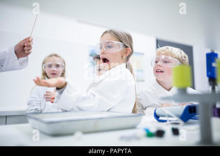 Frightened schoolgirl in science class Stock Photo