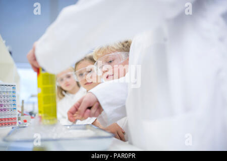 Pupils in science class watching teacher experimenting Stock Photo