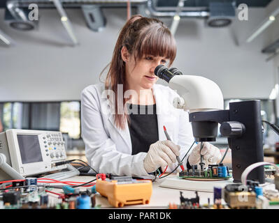 Female technician checking circuit board Stock Photo