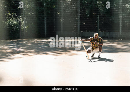 Cool young man in skate park, using smartphone Stock Photo