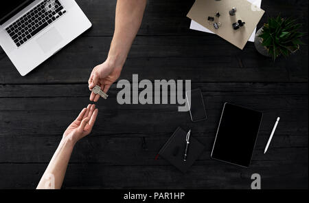 People handing over keys in office Stock Photo