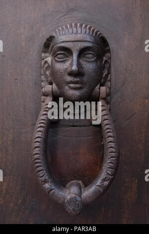 Vintage egyptian pharaoh face door knocker on a wooden door. Stock Photo