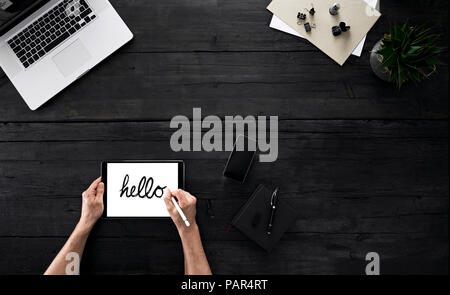 Person using digital tablet in office, writing hello with stylus Stock Photo