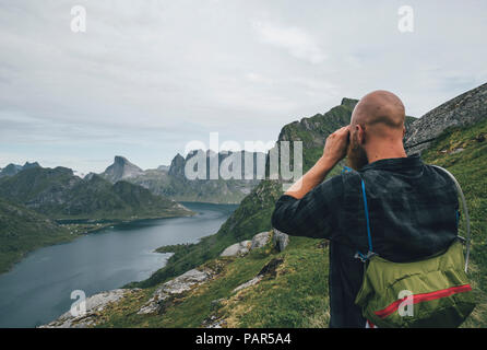 Norway, Lofoten, Moskenesoy, Man looking over Kjerkefjord Stock Photo