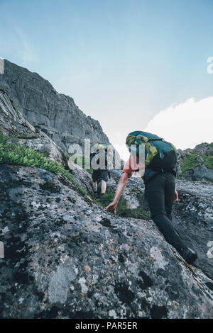 Norway, Lofoten, Moskenesoy, Young man hiking in the mountains Stock Photo
