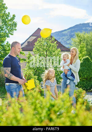 Austria, Wattens, happy family playing together in a park Stock Photo