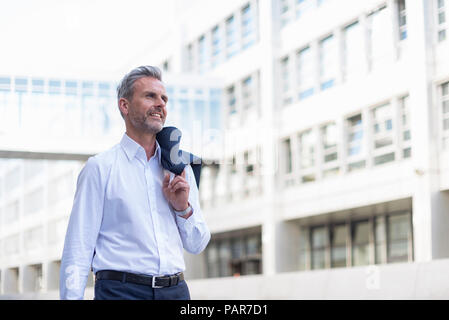 Businessman walking in front of modern office building Stock Photo