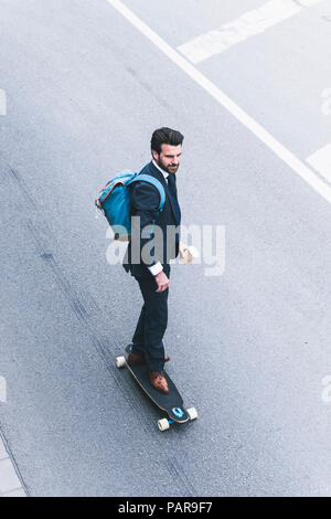 Businessman riding skateboard on the street Stock Photo