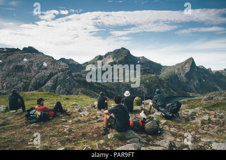 Norway, Lofoten, Moskenesoy, Young men taking a break, looking at the mountains Stock Photo