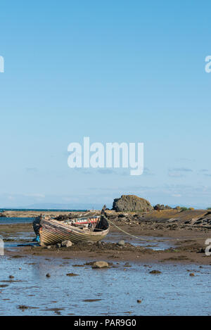 An old fishing boat moored on the beach at low tide in Maidens, Ayrshire, Scotland Stock Photo
