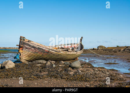 An old fishing boat moored on the beach at low tide in Maidens, Ayrshire, Scotland Stock Photo