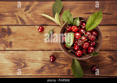 Top view of cherries in a bowl on dark wooden background. Copy space. Stock Photo