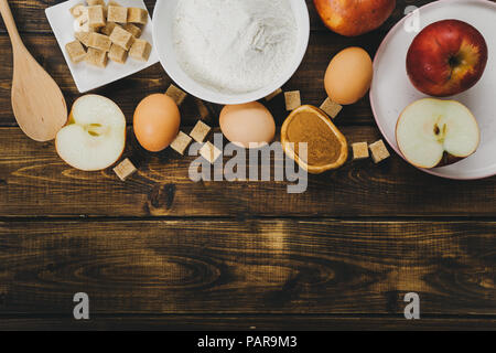 Flat lay of ingedients for apple pie on rustic wooden background. Copy space Stock Photo