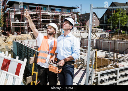 Construction worker talking to man on construction site Stock Photo