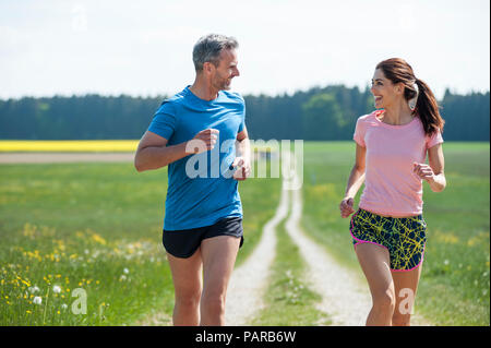 Couple running on field path Stock Photo