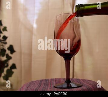 Red Wine Pouring into Tinted Glass Stock Photo