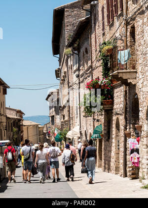Tourists walking on the charming medieval Via Frate Elia in the old town, Assisi, Umbria, Italy Stock Photo