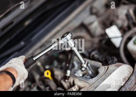 Mechanic changing broken car spark plugs. Car repair. Replacement of spark plugs Stock Photo
