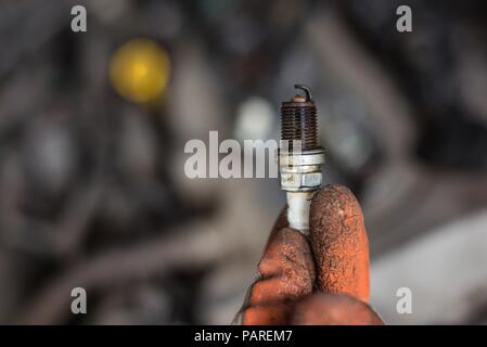 Mechanic holding old broken car spark plugs. Car repair. Replacement of spark plugs Stock Photo