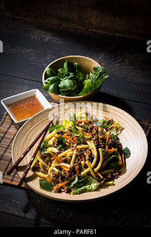 Asian mincemeat salad with macaroni, ginger, chili, garlic, carrot, spring onion, soy lemon sauce Stock Photo