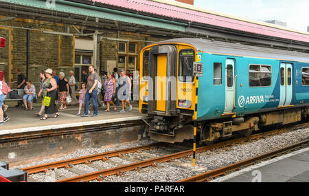 Crowd of passengers walking along a platform after arriving in Swansea railway station. Stock Photo