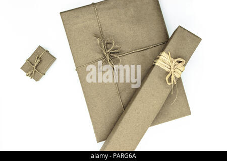 Mix of various sizes gift boxes wrapped in beige paper and bundled with different ribbons on white background Stock Photo