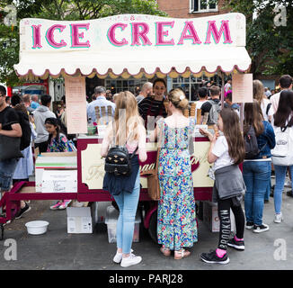A long queue of people waiting in line at an old fashioned ice cream stand during a heatwave and hot weather in York, UK Stock Photo