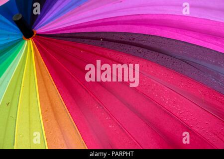 The umbrella of colored flowers lies after the rain. It is painted in various bright colors and shades of pink. Stock Photo