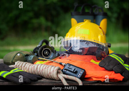Outfit of Firefighter placed on wooden table background, Fire equipment concept. Stock Photo