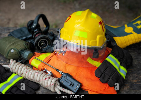 Outfit of Firefighter placed on wooden table background, Fire equipment concept. Stock Photo