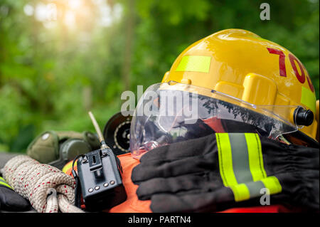 Outfit of Firefighter placed on wooden table background, Fire equipment concept. Stock Photo