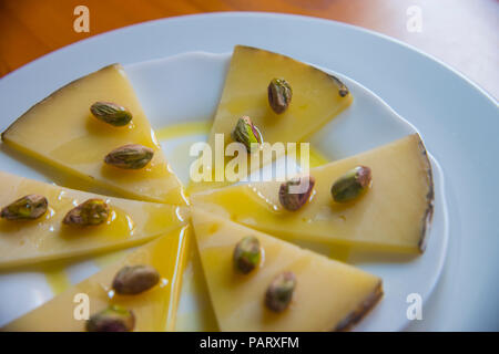 Manchego cheese with pistachios and olive oil. Spain. Stock Photo