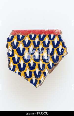 Inlay, feather pattern. Dimensions: H. 3.3 × W. 3.5 cm (1 5/16 × 1 3/8 in.). Date: 200 BC-100 AD.  A mosaic glass technique allowed multiples of an image to be created: a figural or design composition was made by bundling colored glass canes, which were then drawn out into a long bar. The bar was then sectioned at right angles, probably by striking the bar with appropriate tools, to produce small inlay tiles. The tile would then be smoothed and polished on the face intended to appear outwards. Museum: Metropolitan Museum of Art, New York, USA. Stock Photo