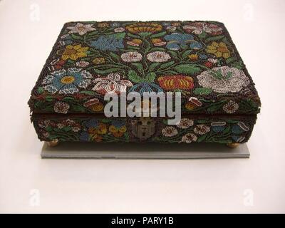 Box with beadwork. Culture: British. Dimensions: H. 3 1/4 x L. 10 1/8 inches (8.3 x 25.7 cm). Date: last quarter 17th century.  Imported glass beads were used sparingly in English embroidery from the 1630s on. Here, the entire surface of a wooden box is covered with strings of Venetian beads forming a pattern of symmetrical flowers against a dark ground. Museum: Metropolitan Museum of Art, New York, USA. Stock Photo