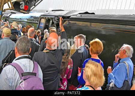 Crowd of people on railway station platform trying to reach front of Flying Scotsman to get photographs at Victoria train station London England UK Stock Photo