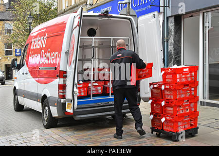 Driver home delivery van loading in narrow street online food shopping orders from nearby Iceland supermarket store in Hexham Northumberland England Stock Photo