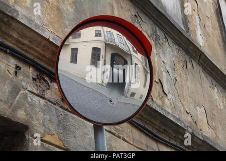 Wall of old building with peeling plaster. Reflection of a neighboring house in the mirror. Old town street. Vilnius, Lithuania. Eastern Europe, trave Stock Photo