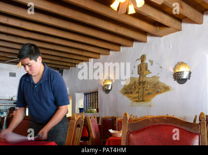 Waiter sets table inside the Oldest restaurant in old town Albuquerque, La Placita, with Spanish settlers honored with frescoes on walls Stock Photo