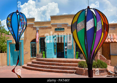 handcrafted paper  art of hot air balloons hang from under potico of shopping district in Old Town Albuquerque, NM across from Aobe Complex of shops a Stock Photo