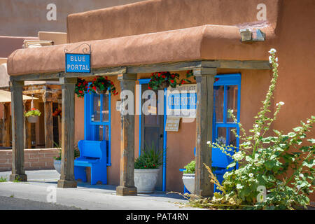 Brilliant blue trim on old adobe building with blue bench and planters outside of the BLUE PORTAL gift shop in old town Albuquerque, NM Stock Photo