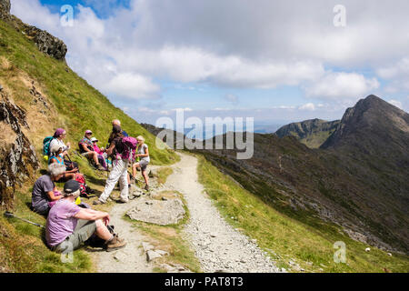 Hikers resting on Watkin Path from Mount Snowdon to Y Lliwedd in mountains of Snowdonia National Park (Eryri). Cwm Llan, Gwynedd, Wales, UK, Britain Stock Photo