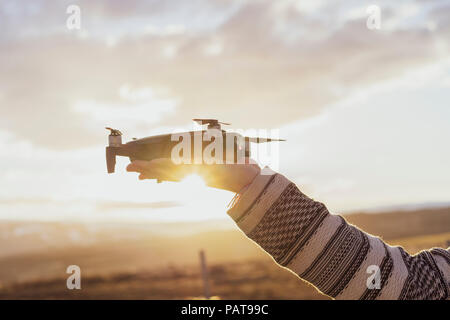 Iceland, man holding a drone at sunset Stock Photo