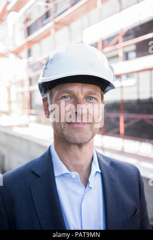 Portrait of confident architect wearing hard hat on construction site Stock Photo